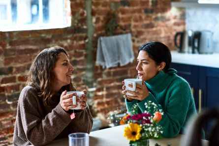 Two women having a hot drink together at a table