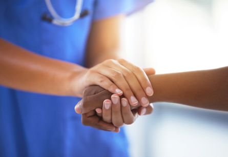 Nurse holding patient's hand